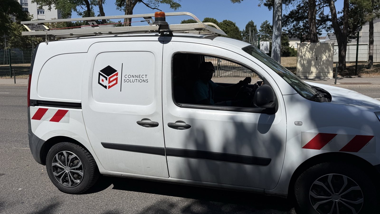 Véhicule d'intervention Connect Solutions floqué du logo, équipé d'une galerie de toit et d'une échelle